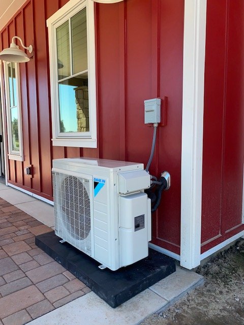 Daikin ductless mini-split condenser installed beside a building